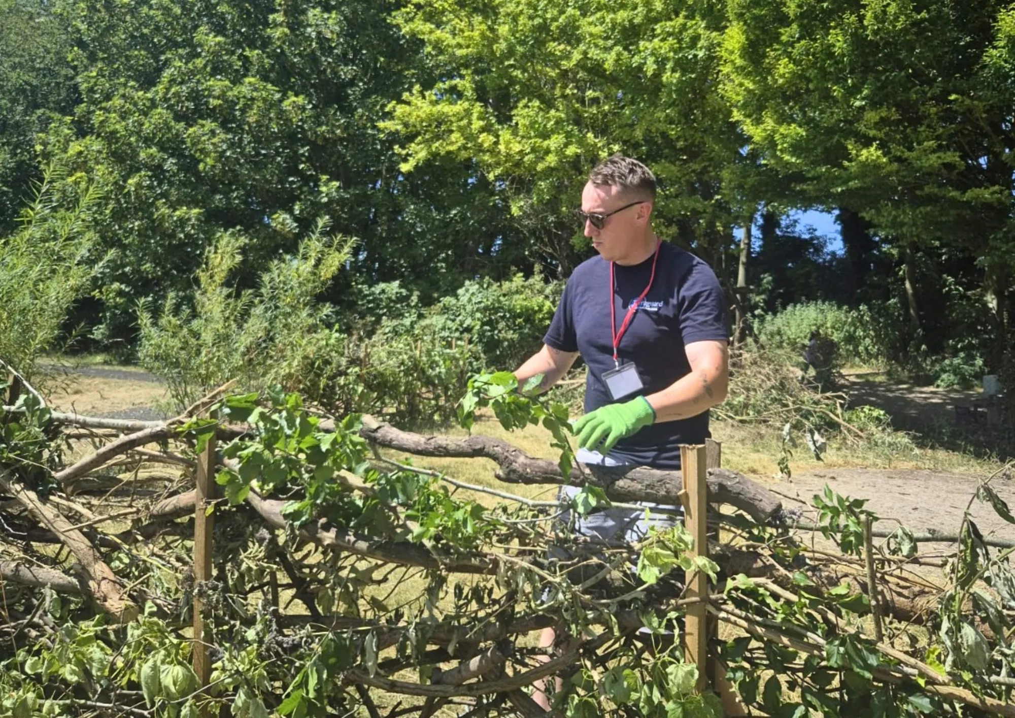 A Terraguard team member clearing hedgerow, volunteering at a community conservation event