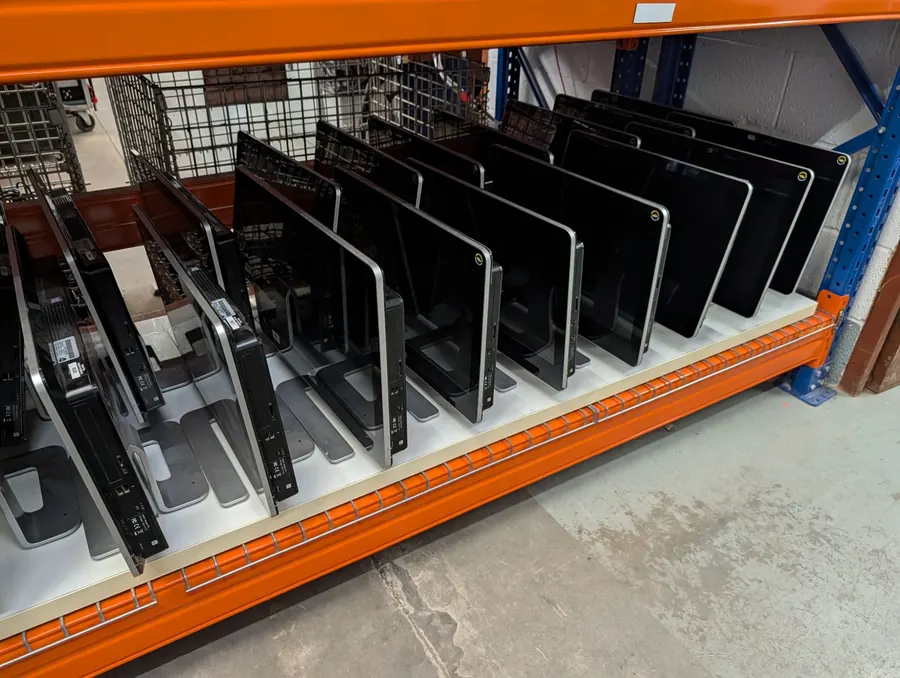 Racks of collected monitors and computers, logged and waiting to be processed